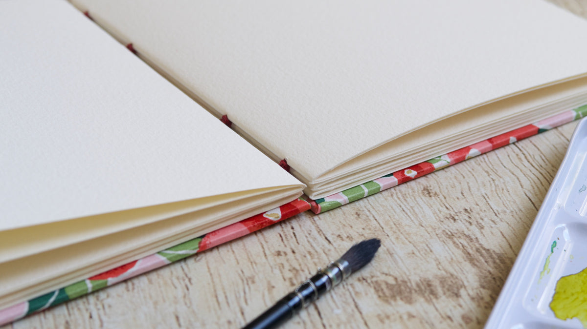carnet d'aquarelle bien ouvert à plat grâce à la reliure copte