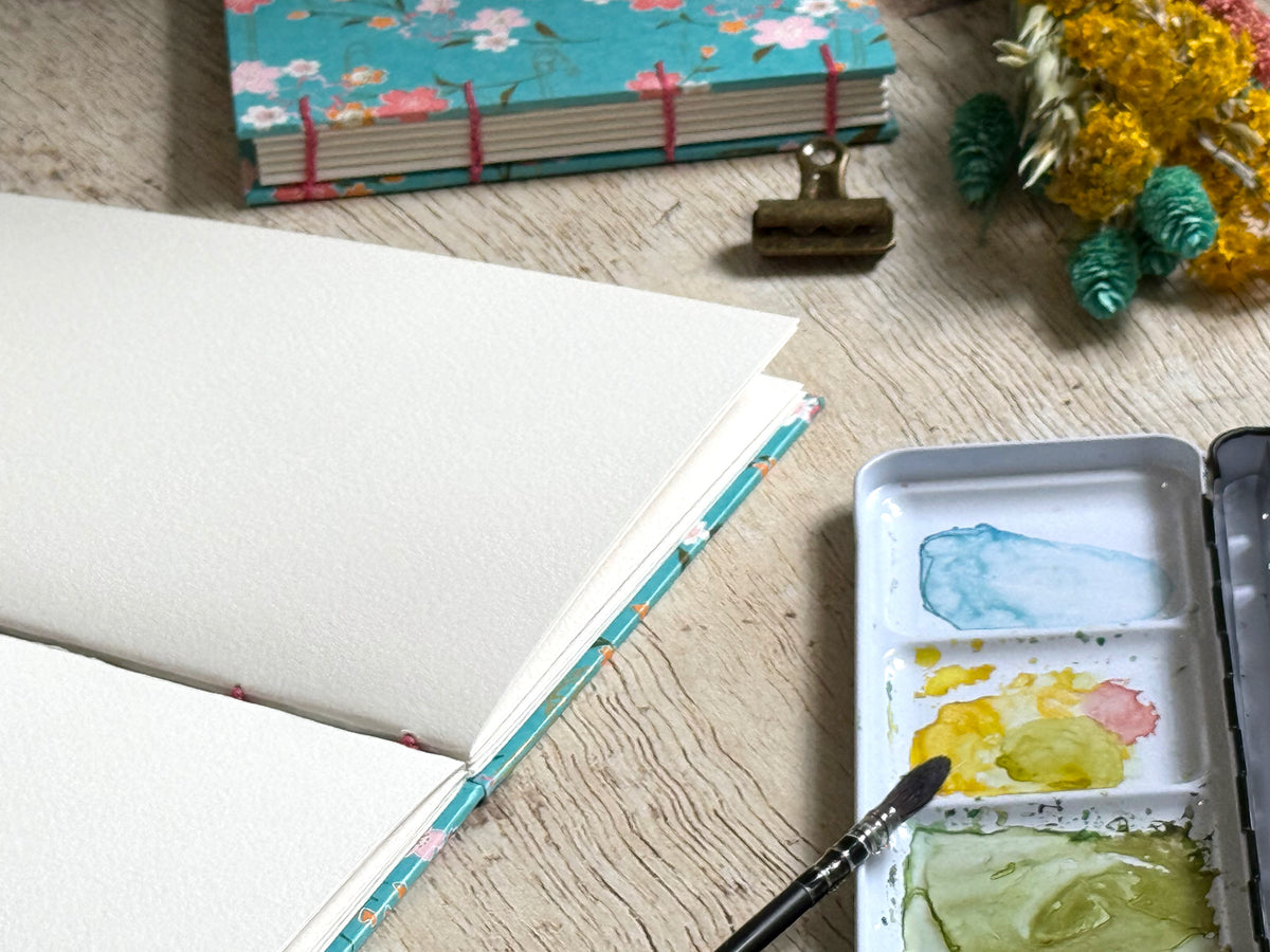 carnet d'aquarelle ouvert bien à plat grâce à la reliure copte faite main