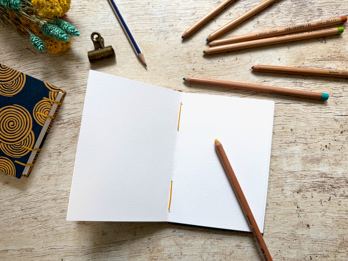 Carnet de croquis A6 portrait Spirales bien ouvert à plat grâce à la reliure copte